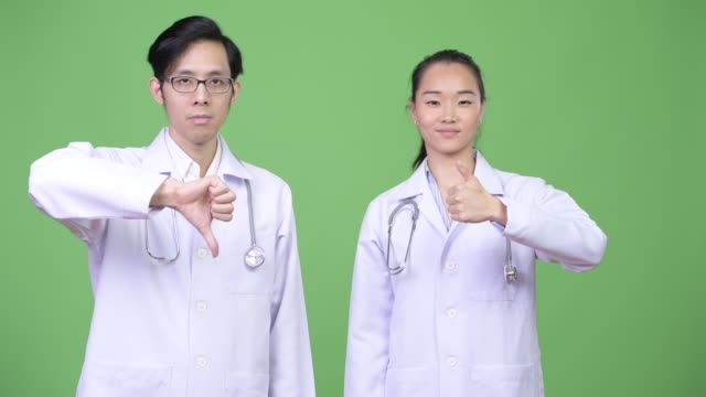 Médicos-de-la-joven-pareja-asiática-teniendo-diferentes-decisiones-juntos