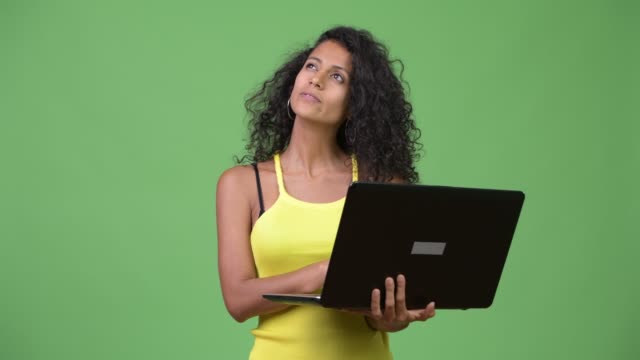 Junge-schöne-Hispanic-Frau-denken-während-mit-laptop