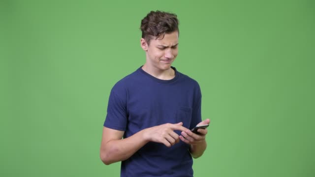 Young-teenage-boy-using-phone-and-getting-bad-news