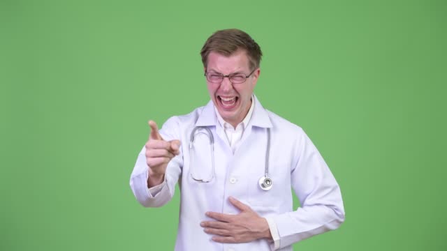 Médico-hombre-riendo-y-señalar-con-dedo