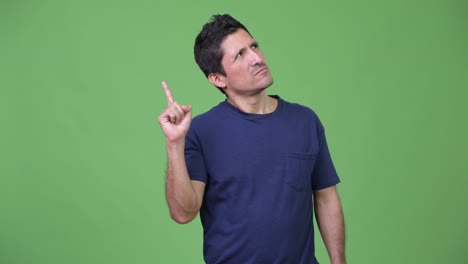 Hispanic-man-thinking-while-pointing-finger-up