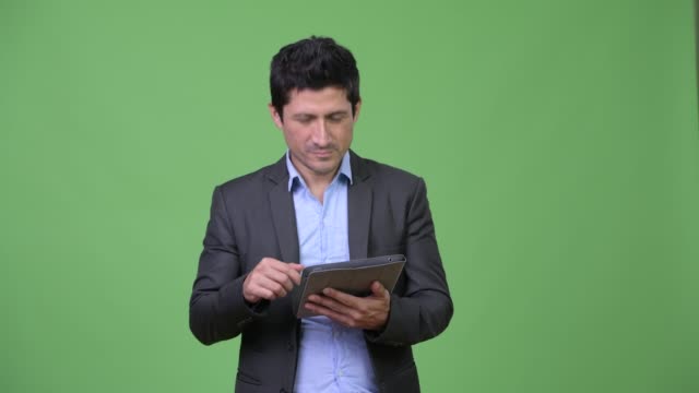 Glücklich-Hispanic-Geschäftsmann-denken-bei-der-Verwendung-von-digital-Tablette