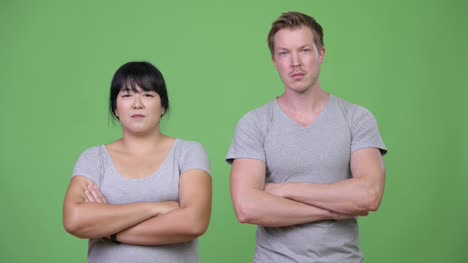 Happy-young-multi-ethnic-couple-with-arms-crossed-together