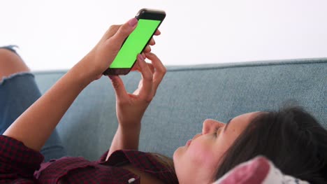 Close-Up-Of-Woman-Lying-On-Sofa-At-Home-Using-Mobile-Phone