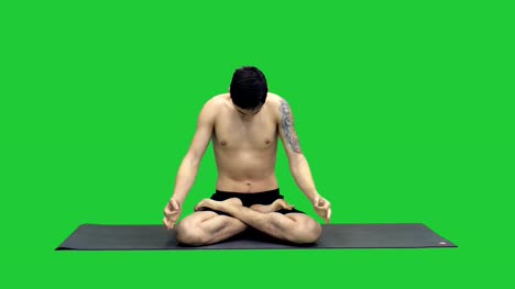 Junger-Mann,-Yoga-zu-praktizieren-im-Lotussitz-auf-einem-Green-Screen,-Chroma-Key