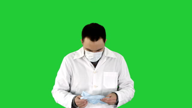 Porträt-der-medizinischen-Doktor-putting-Maske-und-Hut-auf-auf-einem-Green-Screen,-Chroma-Key