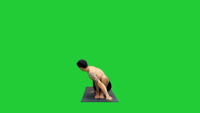 Young-man-doing-squat-with-twist-and-bend-yoga-on-a-Green-Screen,-Chroma-Key