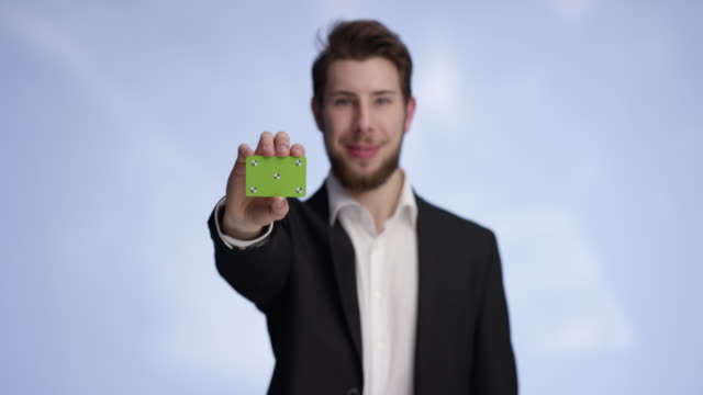 Young-and-attractive-man-presenting-a-buisness-card-into-the-camera