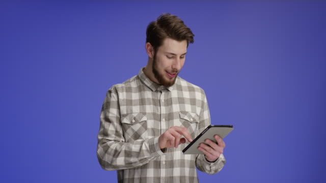 Confident-man-working-on-tablet-and-smiling