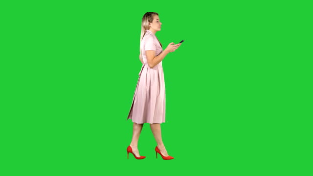 Mujer-bonita-rubia-mediante-mensaje-de-texto-de-teléfono-celular-en-una-pantalla-verde-Chroma-Key