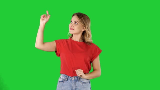 Mujer-joven-feliz-mostrando-un-producto-apuntando-con-su-dedo-a-lados-presentación-sobre-una-pantalla-verde-Chroma-Key