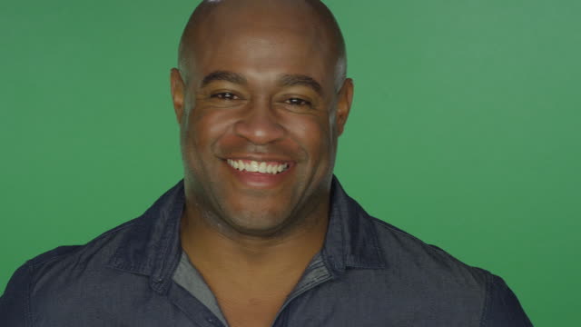 African-American-man-smiling,-on-a-green-screen-studio-background