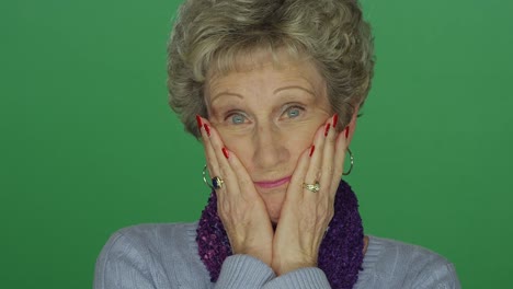 Older-woman-looking-taken-aback,-on-a-green-screen-studio-background