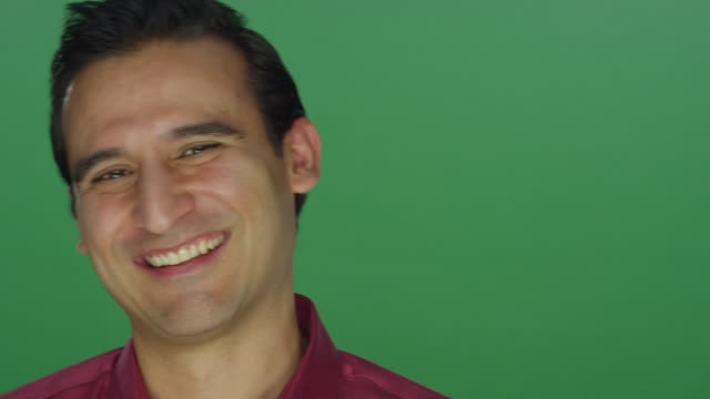 Ethnic-man-laughing-and-smiling,-on-a-green-screen-studio-background