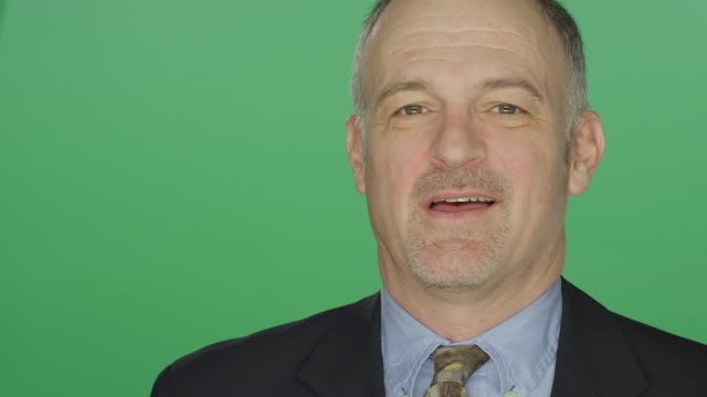 Middle-aged-businessman-smiling,-on-a-green-screen-studio-background