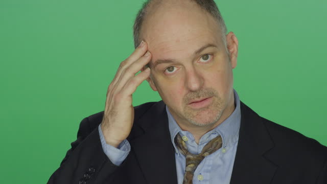 Middle-aged-businessman-looking-exhausted,-on-a-green-screen-studio-background