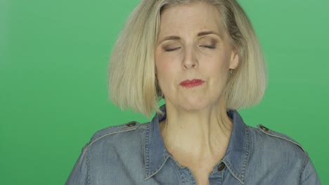 Beautiful-older-woman-looking-worried,-on-a-green-screen-studio-background