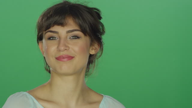 Schöne-Brünette-Frau-lächelnd-und-Flirten,-auf-einem-green-Screen-Studio-Hintergrund