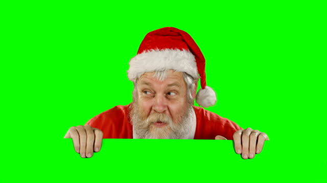 Überrascht-Weihnachtsmann-versteckt-sich-hinter-green-screen