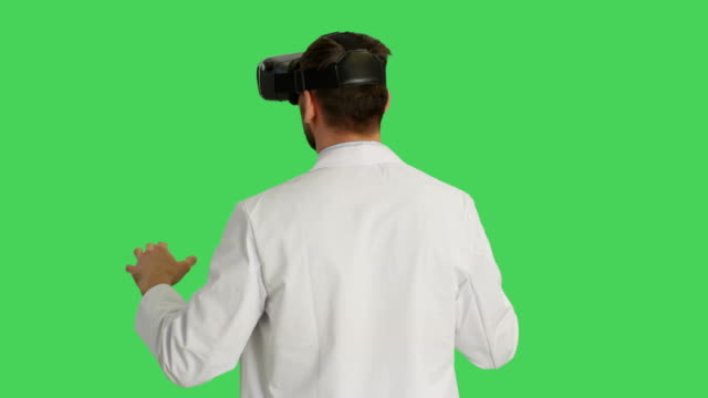 Mitte-Schuss-eines-Wissenschaftlers-VR-Kopfhörer-tragen.-Kamera-dreht-sich-um-ihn-herum.-Hintergrund-ist-Green-Screen.
