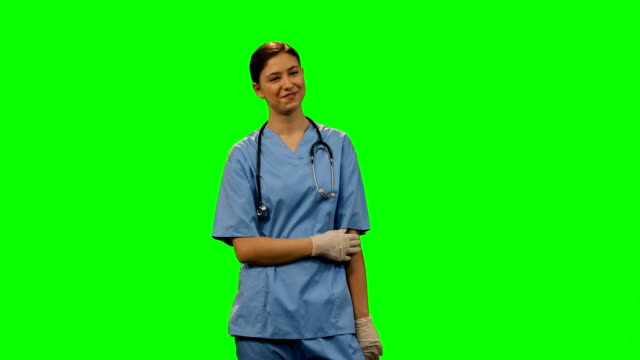 Happy-female-surgeon-standing-against-green-screen