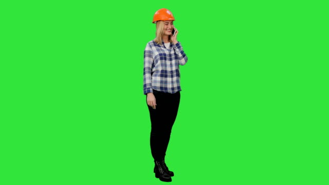 Frau-in-orange-Bauarbeiterhelm,-ruft-das-Telefon-auf-einem-Green-Screen,-Chroma-Key