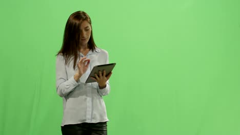 Frau-ist-einen-Tablet-Computer-verwenden,-auf-ein-Mock-up-green-Screen-im-Hintergrund.