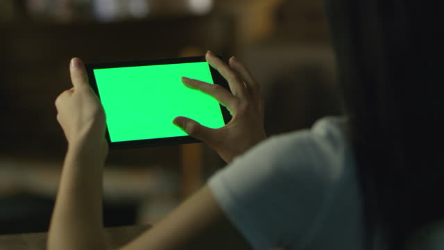 Chica-adolescente-es-utilizar-Tablet-PC-con-pantalla-verde-en-el-modo-de-retrato-en-la-noche.-Estilo-de-vida-casual.