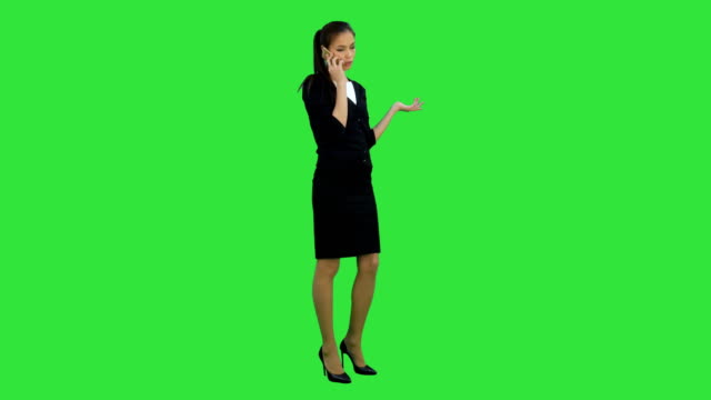 Skeptisch-und-unglückliche-junge-Frau-telefonieren-mit-Handy-auf-einem-Green-Screen,-Chroma-Key