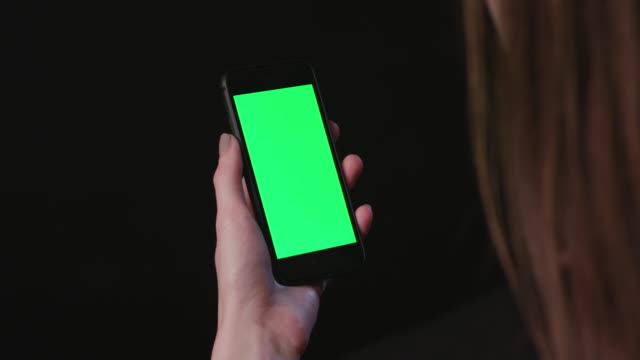 Frau-ist-Holding-Handy-mit-grünen-Bildschirm-tippen-Sie-auf