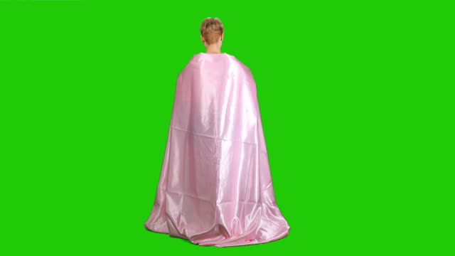 Pretty-girl-in-pink-satin-bedsheet-poses-for-camera-at-green-background