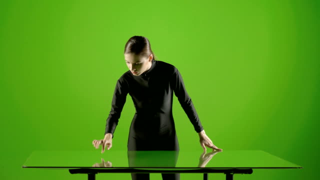 Attractive-girl-young-fashion-model-virtual-touch-screen-gesture-shot-in-green-screen-studio-.-Interactive-futuristic-gesture-.-Medium-shot-.-Prores-shoot-on-Blackmagic-Ursa-Mini-Pro