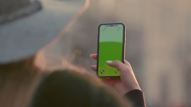 Gorgeous-Mädchen-mit-ihrem-Smartphone-in-der-Stadt-Hintergrund-green-Screen-Chroma-key