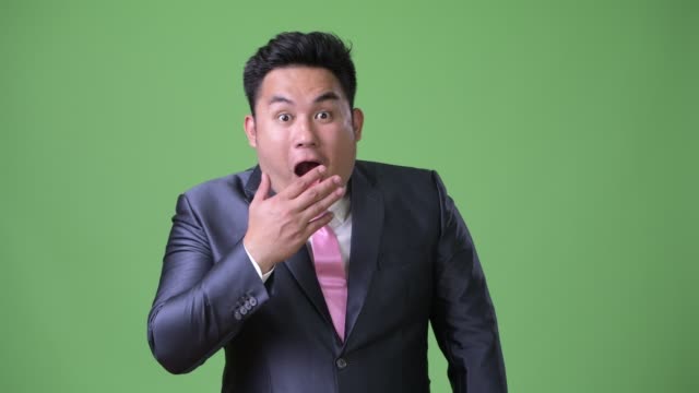 Joven-guapo-empresario-asiático-con-sobrepeso-sobre-fondo-verde