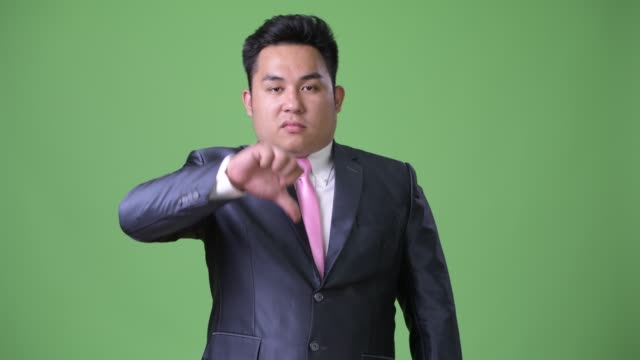 Junge-hübsche-Übergewicht-asiatischen-Geschäftsmann-vor-grünem-Hintergrund