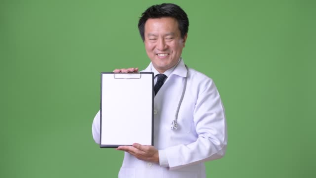 Reifer-Mann-japanische-Arzt-vor-grünem-Hintergrund