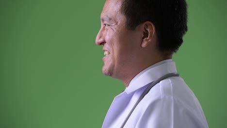 Reifer-Mann-japanische-Arzt-vor-grünem-Hintergrund