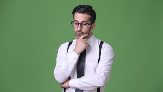 Young-handsome-bearded-Persian-businessman-against-green-background