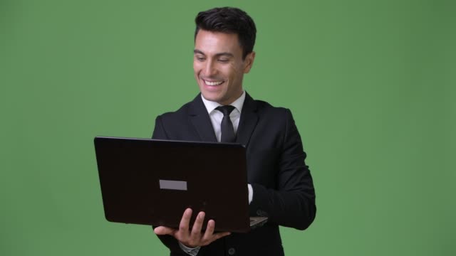 Young-handsome-Hispanic-businessman-against-green-background