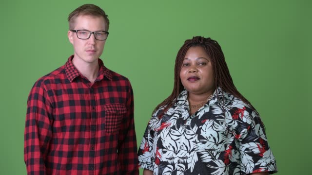 Afrikanerin-und-skandinavischen-Jüngling-vor-grünem-Hintergrund-zusammen-mit-Übergewicht