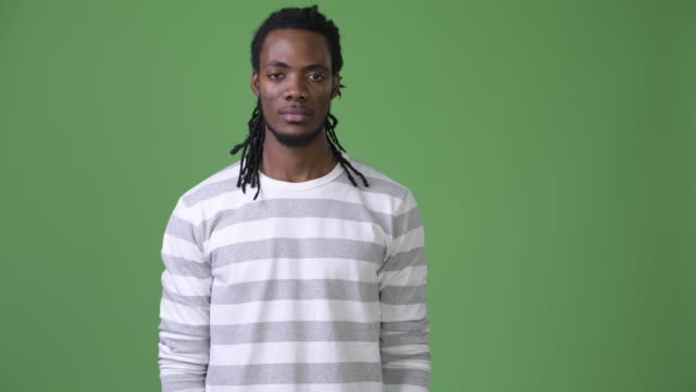 Young-handsome-African-man-with-dreadlocks-against-green-background