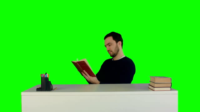 Retrato-de-un-hombre-estudiantes-leyendo-un-libro-en-una-pantalla-verde