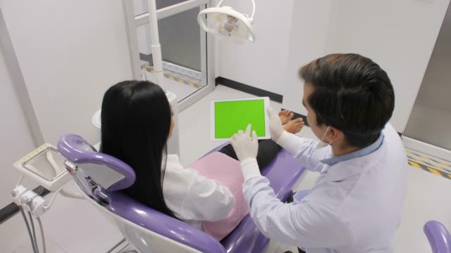 Zahnarzt-erklärt-Verfahren-für-Patienten-von-Greenscreen-tablet
