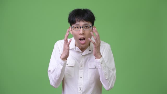 Junge-asiatische-Geschäftsmann-schockiert-während-den-Mund
