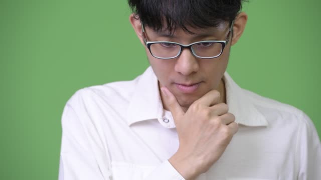 Traurige-junge-asiatische-Geschäftsmann-denken-beim-Blick-nach-unten