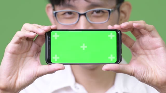 Junge-asiatische-Geschäftsmann-zeigt-Handy-mit-Kamera