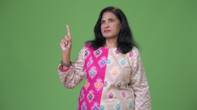 Mature-beautiful-Indian-woman-thinking-while-pointing-finger-up