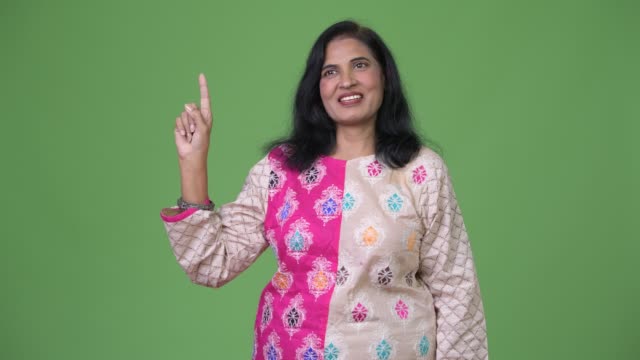 Mature-happy-beautiful-Indian-woman-thinking-while-pointing-finger-up