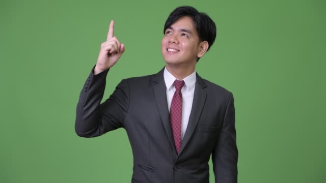 Young-handsome-Asian-businessman-pointing-finger-up