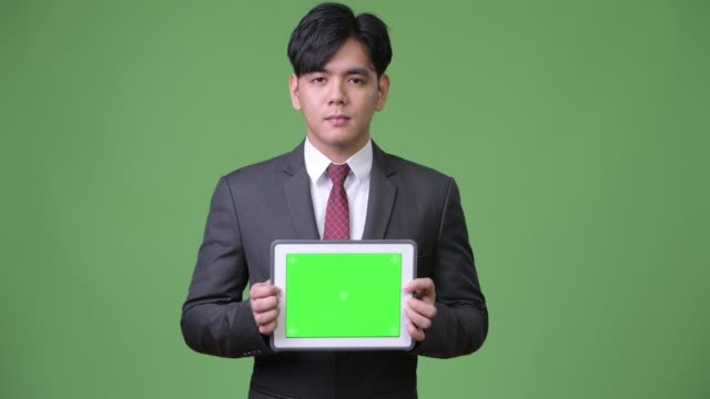 Junge-hübsche-asiatische-Geschäftsmann-mit-digital-Tablette